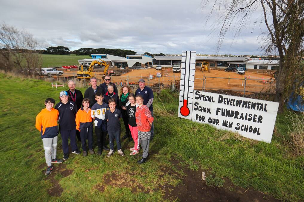 Fundraiser: Students, teachers and stakeholders pose out the front of the Warrnambool SDS work site, they have created a temperature gauge to show off the amount of money raised. Picture: Morgan Hancock