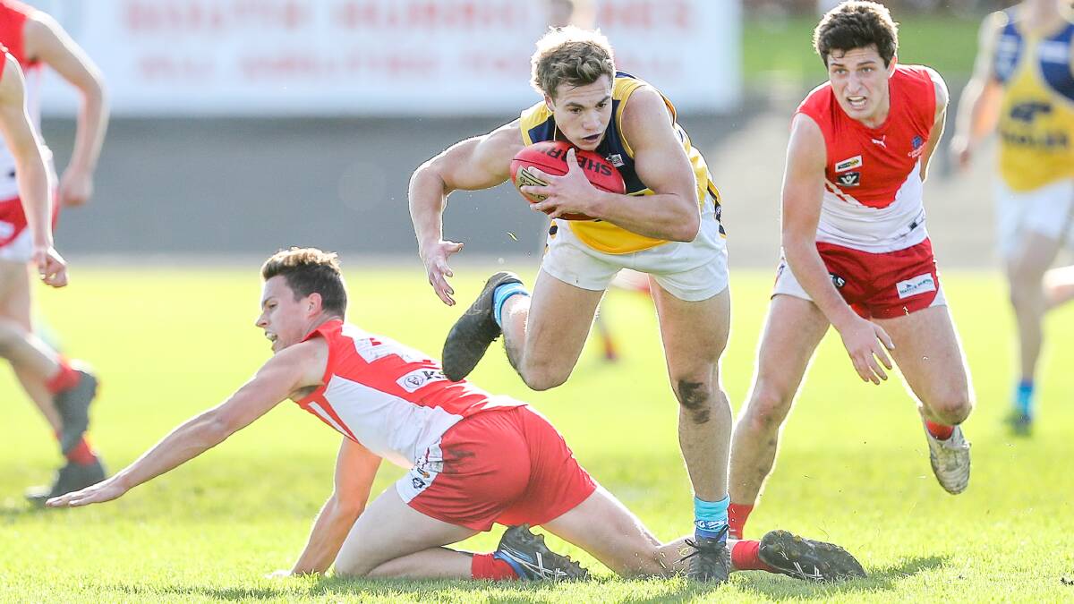 WINNERS: North Warrnambool's Sam Slattery tries to regain his balance with ball in hand. Picture: Morgan Hancock