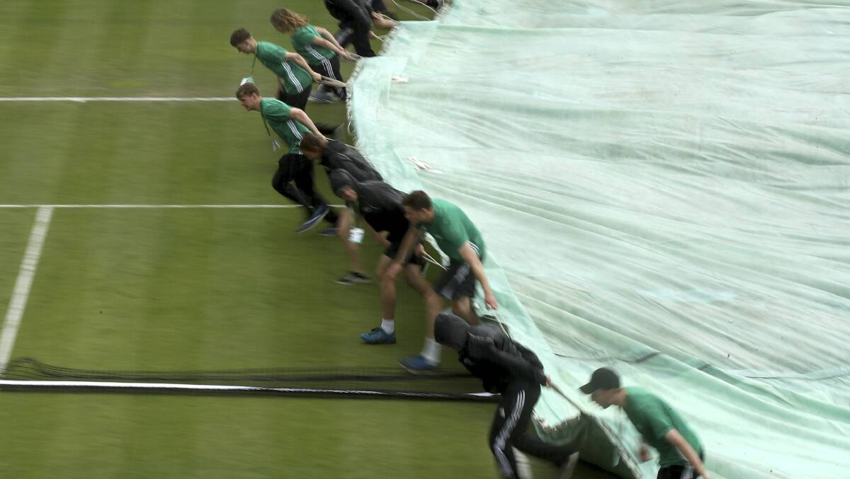 The covers are brought out as rain delays play during the Nature Valley Open tennis tournament in Nottingham, England overnight. Authorities have reported several deaths across Europe as storms bringing high winds and torrential downpours.
