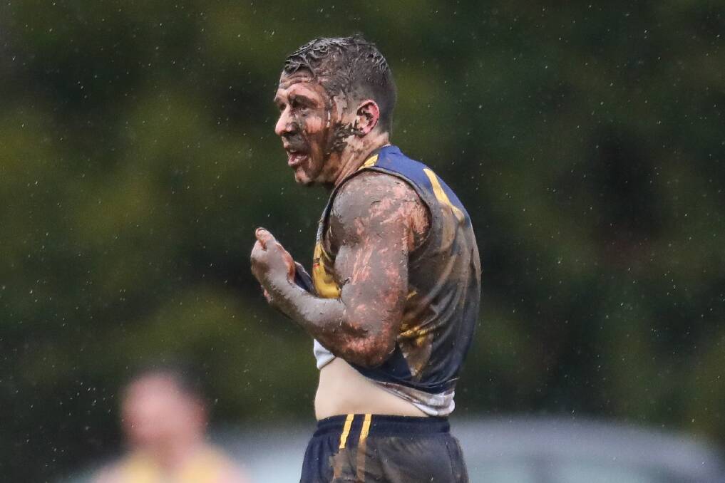 CAKED IN MUD: North Warrnambool Eagles' Jarryd Lewis wipes mud from his face as rain falls at Bushfield on Saturday. Picture: Morgan Hancock
