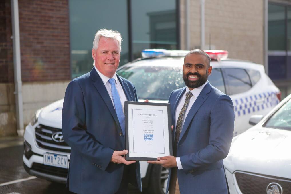 Hard work pays off: Warrnambool Senior Sergeant Shane Keogh is presented with an award from Crime Stoppers' Srithar Visuasam. Picture: Morgan Hancock