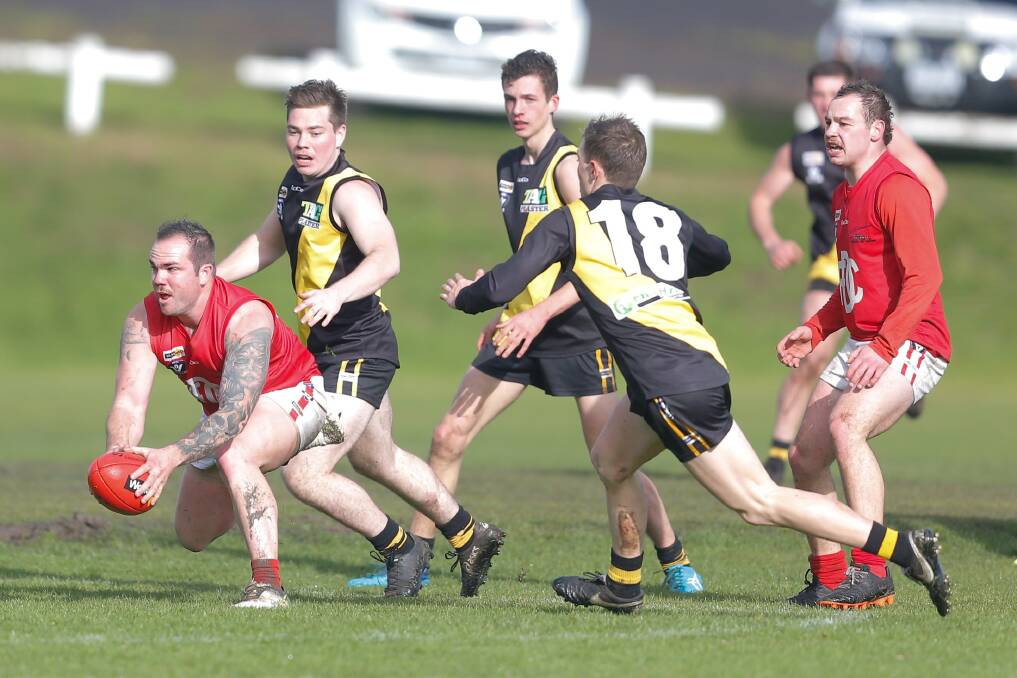 OUTNUMBERED: Dennington's Tully Allwood gathers the ball as a pack of Merrivale Tigers hunt as one. Picture: Mark Witte