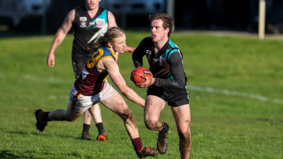 OFF AND RUNNING: South Rovers Eamon Dowd stretches to try and tackle Kolora-Noorat's Luke Justin. Picture: Rob Gunstone