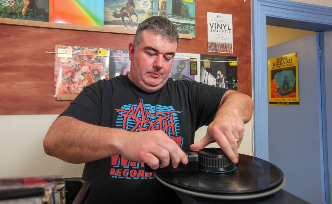 Cleaning up: Shane Godfrey, from Prehistoric Sounds, cleans one of the albums before the Vinyl Swap Meet in Port Fairy. Picture: Rob Gunstone