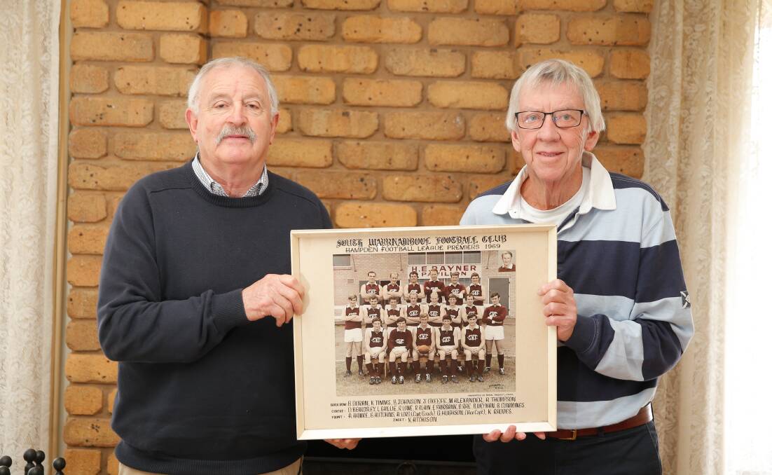 Legends: Les Baillie and Gary Hughson hold up the 1969 South Warrnambool premiership team photo. Picture: Mark Witte