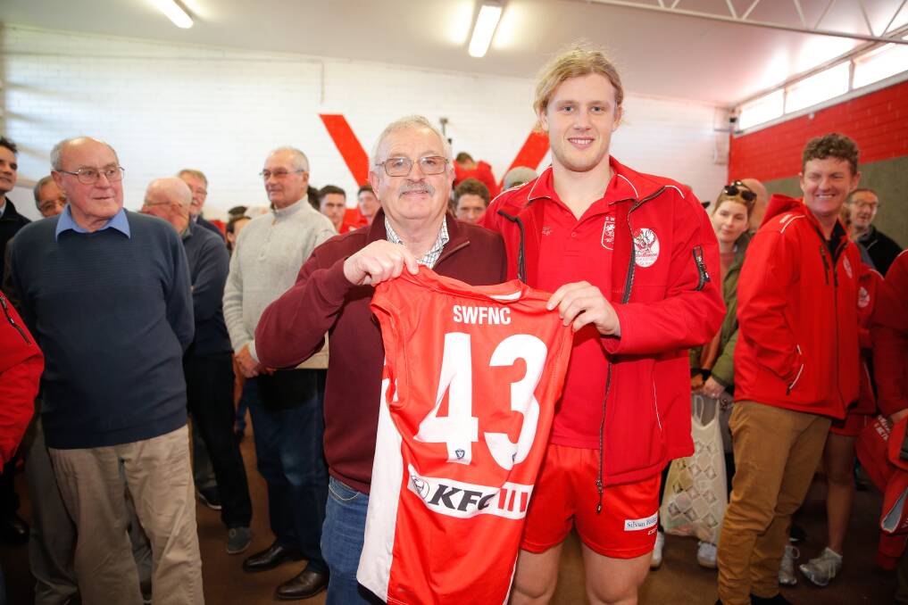 PROUD MOMENT: Grandfather Les Baillie presents Jess Baillie with his first South Warrnambool guernsey ahead of his senior debut on Saturday. Les was also celebrating with the Roosters' 1969 premiership reunion. Picture: Mark Witte