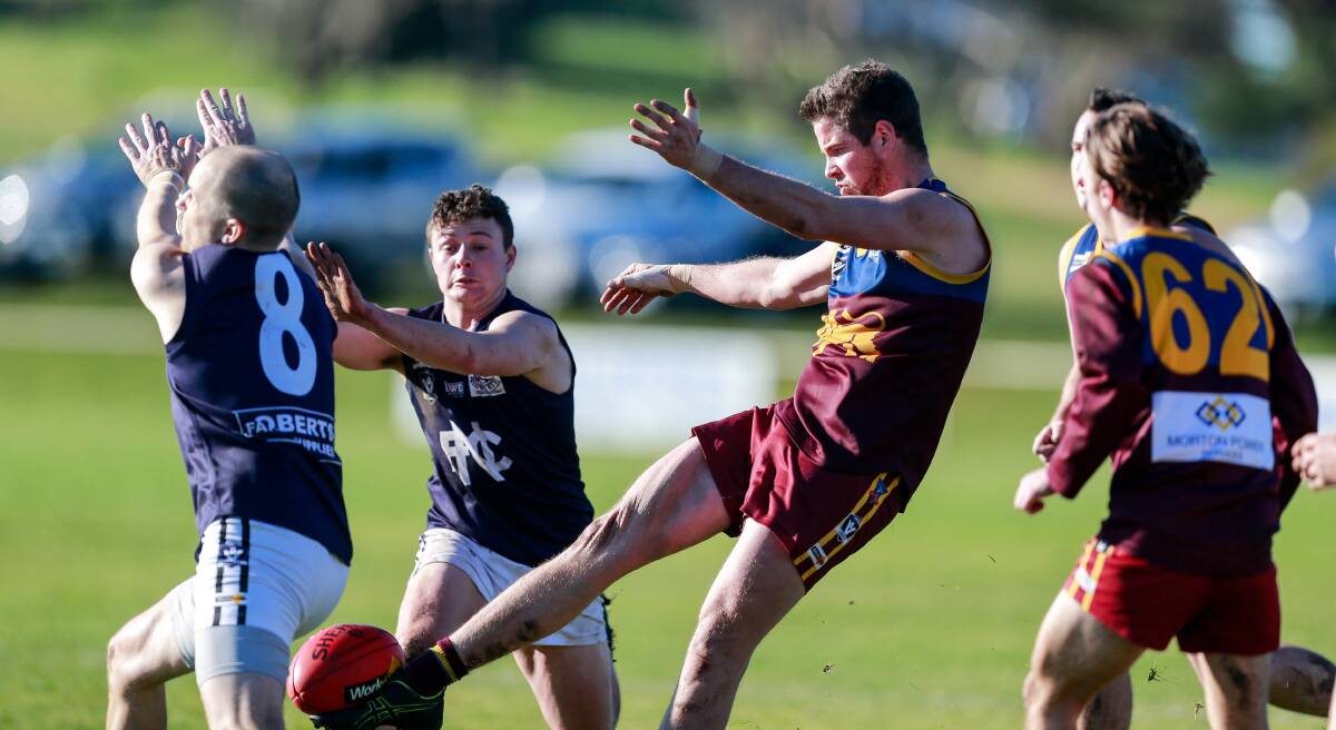 Anzac Day clash: South Rovers' Luke Payne kicks under pressure from Nirranda opponents in season 2019. The Lions and Blues will meet on Anzac Day in 2020. Picture: Anthony Brady