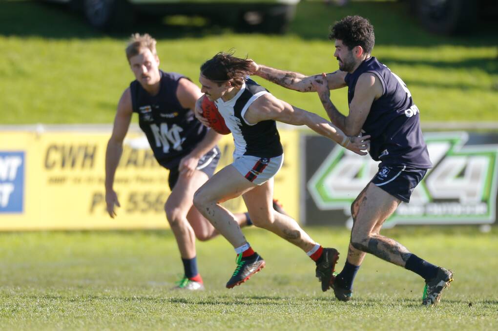 GOTCHA: Koroit's James Gow gets tackled by Warrnambool's Alex Shippard. Picture: Mark Witte