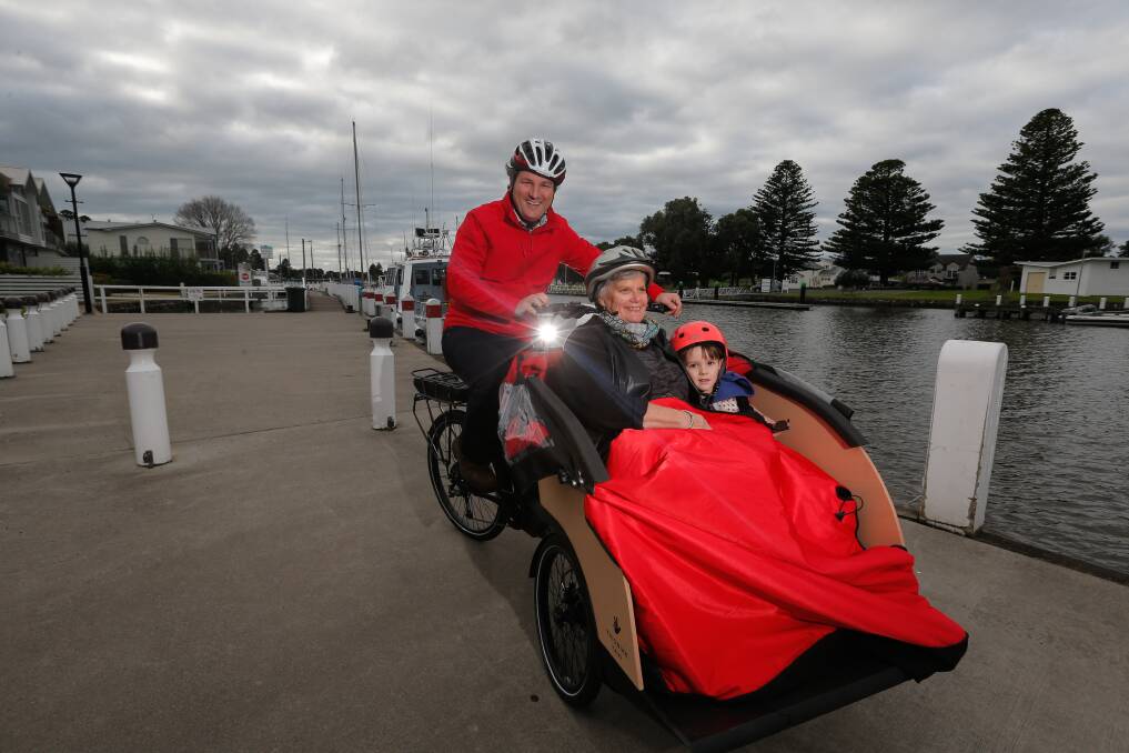SIGHTSEEING: Brendan Donahoo shows Lynda Hughes and Julian Donahoo, 4, the Port Fairy wharf on the new Cycling Without Age bicycle. Picture: Mark Witte