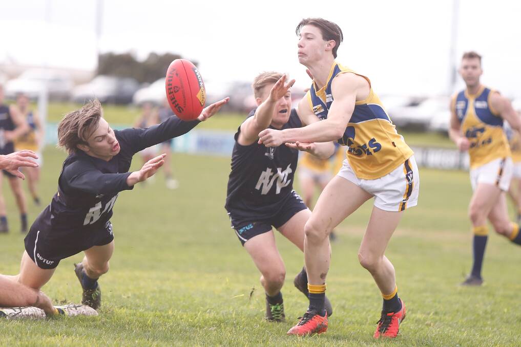 ALMOST: Warrnambool's Austin Steere tries to smother North Warrnambool Eagles' Jackson Couch's handball. Picture: Mark Witte