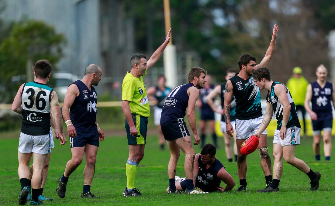 Injury: Players and umpires signal to the bench after Nirranda's Daniel Craven was concussed. Picture: Anthony Brady