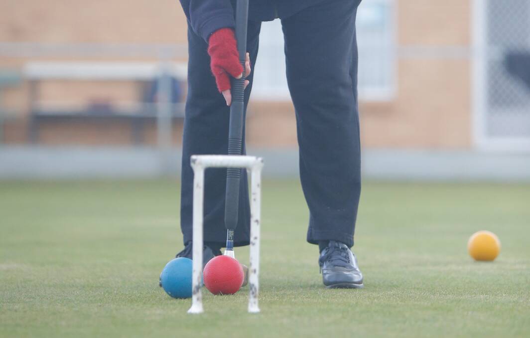 Elaine Fitzgerald shows how to use the croquet mallets. Picture: Mark Witte