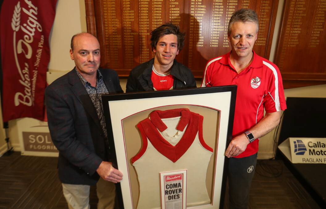 NEVER FORGOTTEN: Shane Daniel, EJ Harvey and Steve Harris hold onto Mick Daniel's old jumper, which will hang up in South Warrnambool's clubrooms. Picture: Morgan Hancock