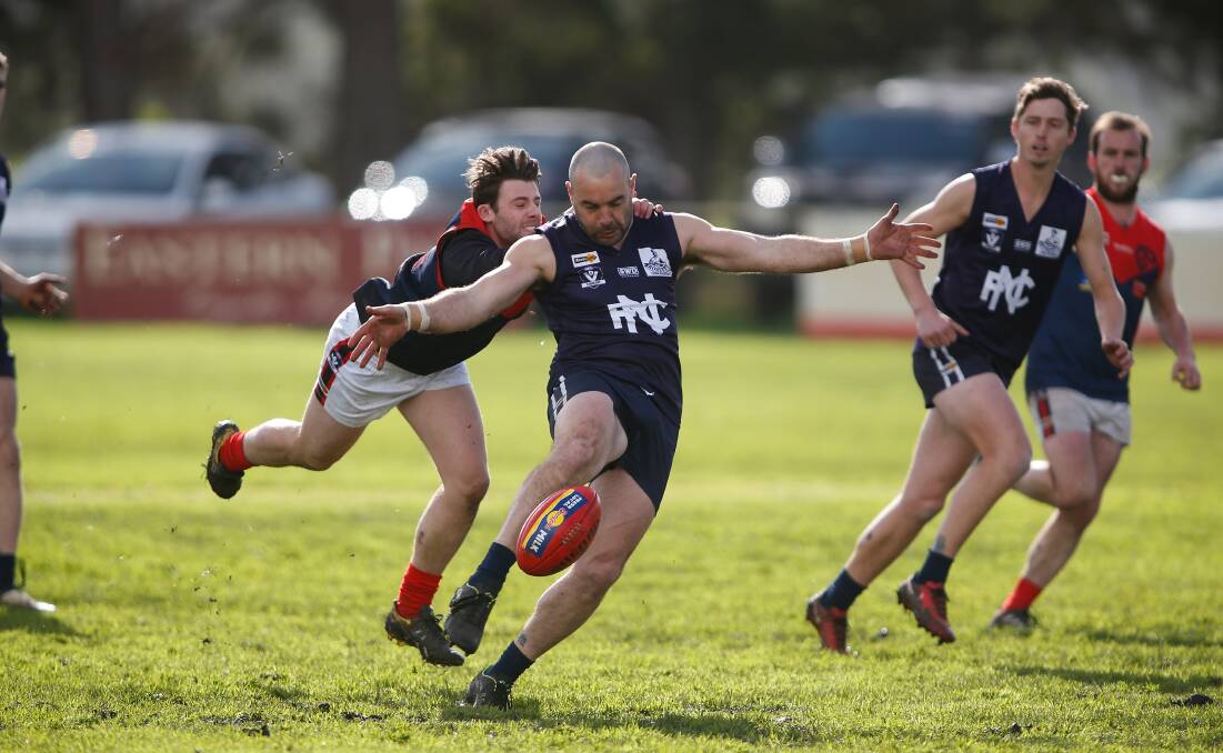 Just in time: Nirranda's Peter McDowall gets a kick away before being tackled. Picture: Mark Witte