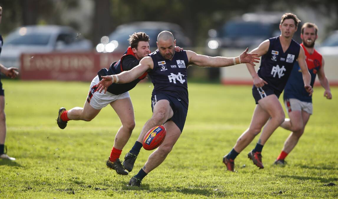 On the boot: Nirranda's Peter McDowall gets a kick away before being tackled. Picture: Mark Witte