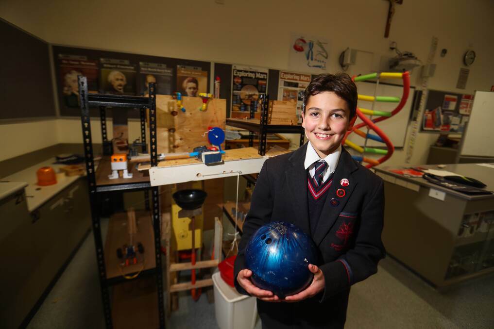 Jace Nepean, 15, shows off the bowling ball that is used in the creation. Picture: Morgan Hancock
