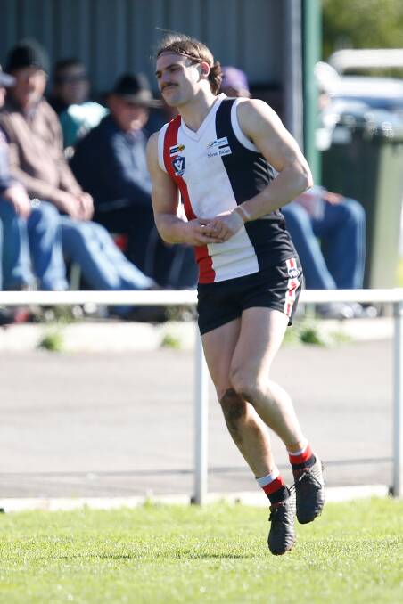 HURT: Koroit's James Gow hobbles off the field after injuring his ankle against Port Fairy. Picture: Mark Witte