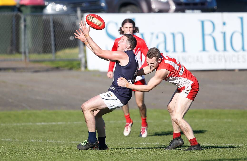 Warrnambool's Jackson Bell marks while South Warrnambool's Hugh Clancey tries to tackle. Picture: Mark Witte