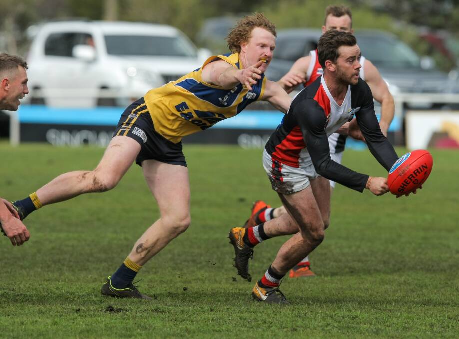 OUT OF REACH: North Warrnambool Eagles' Luke Wines tries to tackle Koroit's James North during the second semi-final at Mortlake on Saturday. Pictures: Rob Gunstone