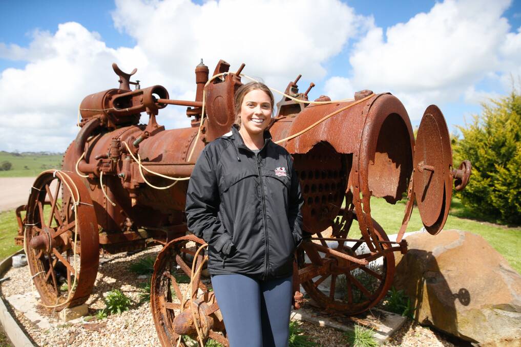 In the backyard: Cobden's Alicia Blain with the ornamental tractor in her family's garden. Picture: Mark Witte