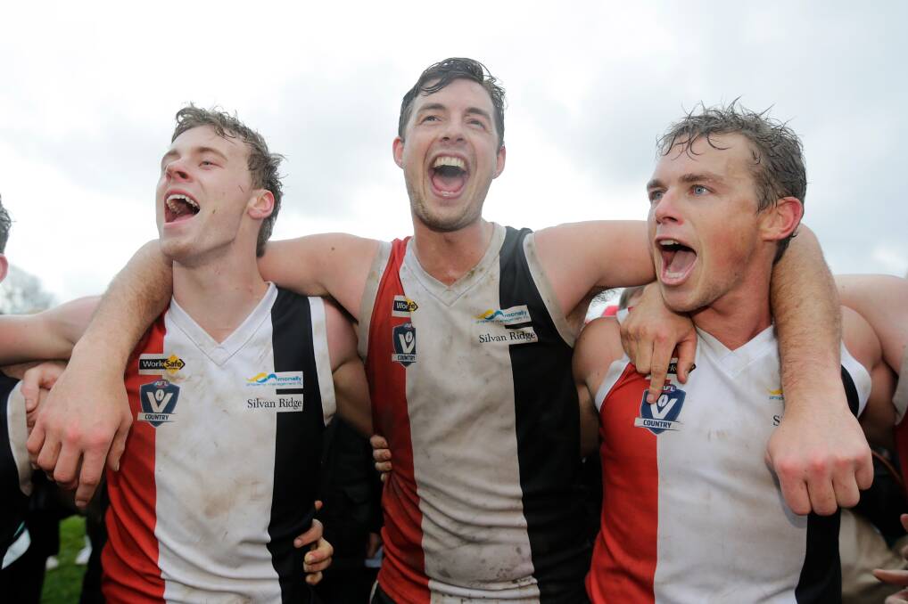 SING IT LOUD: Connor Hinkley (left) celebrates Koroit's premiership with teammates Jeremy Hausler and Tom Couch. Picture: Mark Witte