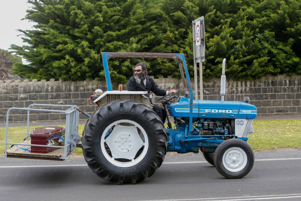 FINAL JOURNEY: Daniel McLean drives a tractor carrying the late Pat Burris, who was a Port Fairy farmer, to the town's cemetery, after a packed-out service at St Patrick's Catholic Church. Picture: Anthony Brady