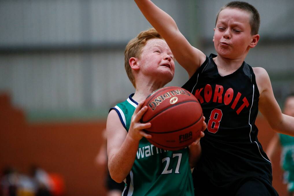 DETERMINED: Warrnambool's Oscar Robinson and Koroit's Cameron Brian wear commitment to the contest on their faces during the Warrnambool Junior Seaside Basketball Classic. Picture: Anthony Brady