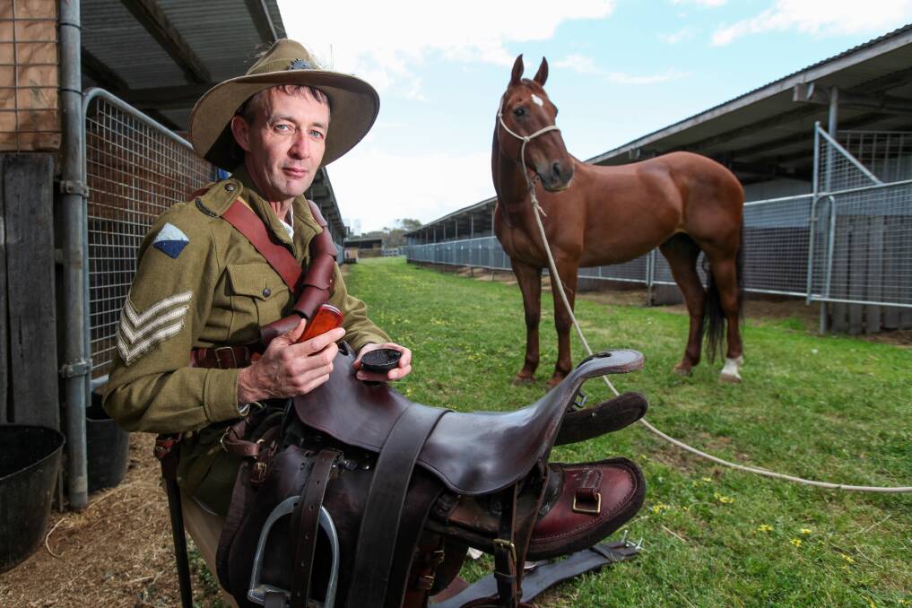 Well polished: Warrnambool Lighthorse unit member David McGinness, with Extra the Australian Stock Horse, gets his gear ready for the Light Horse Association Games on Saturday at the Warrnambool Showgrounds. Picture: Rob Gunstone