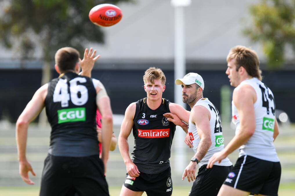 LESSONS: Teenager Jay Rantall, who hails from Warrnambool, works with Steele Sidebottom during a drill at Collingwood pre-season training. Picture: Morgan Hancock