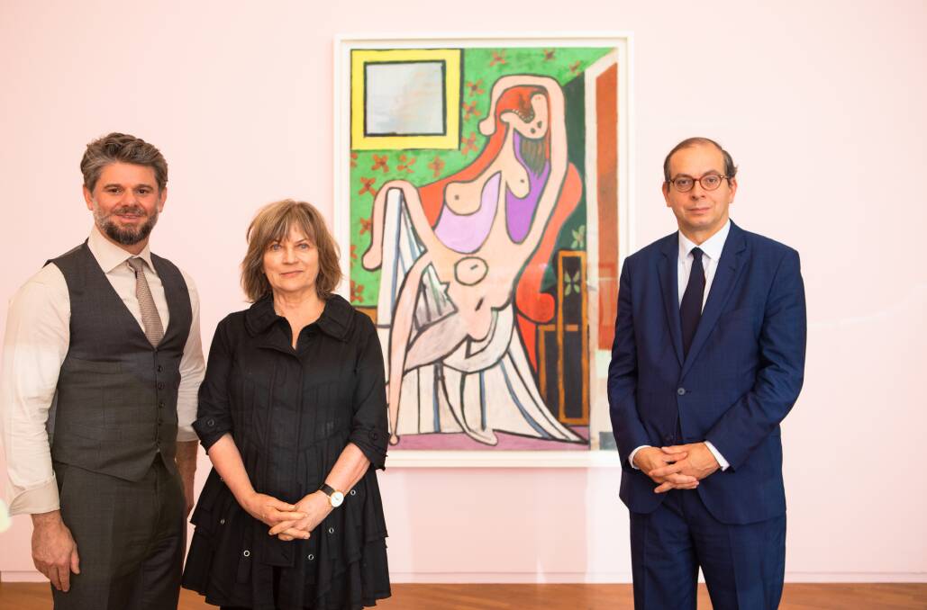 National Gallery of Australia director Nick Mitzevich, head of international art Jane Kinsman, and Musee National Picasso-Paris director Laurent Le Bon standing in front of Large nude on a red chair, 1929, by Pablo Picasso. Picture: Jamila Toderas