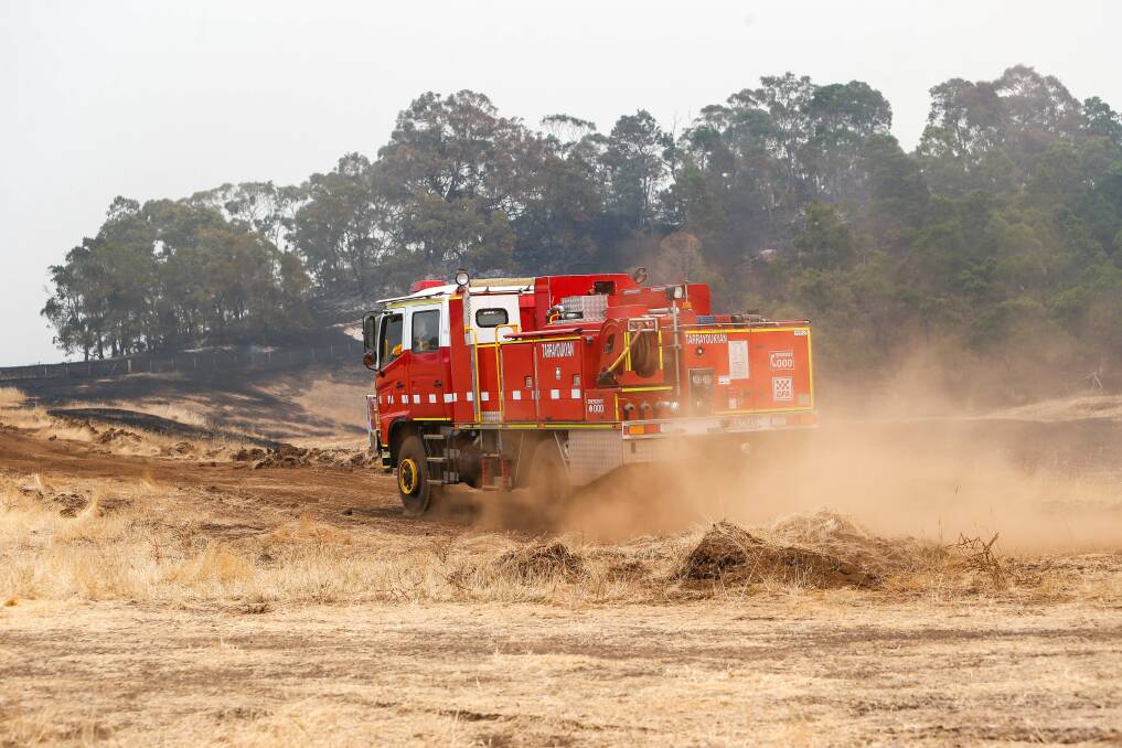 A Firetruck travels along farmland on the outskirts of the fire at Budj Bim National Park. Picture: Anthony Brady
