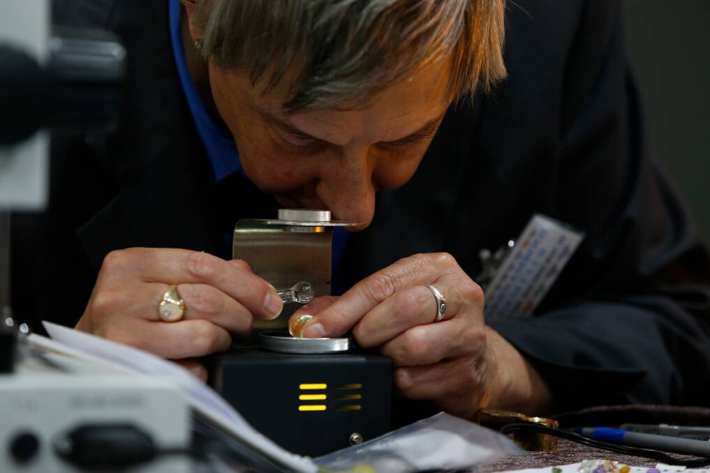 Delicate work: Gemmologist David Heiderich inspects some gems at the Warrnambool Gem show. Picture: Mark Witte