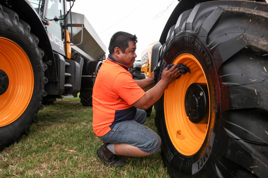 Ready to shine: JCB Ballarat's Chris Catipay makes sure all of the tractors are clean and shiny for the Sungold Field Days. Picture: Rob Gunstone
