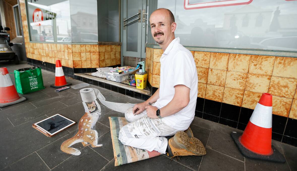 POSITIVITY: Jimmi Buscombe works on his tribute to Colin Cleary outside the Port Fairy IGA. Picture: Anthony Brady