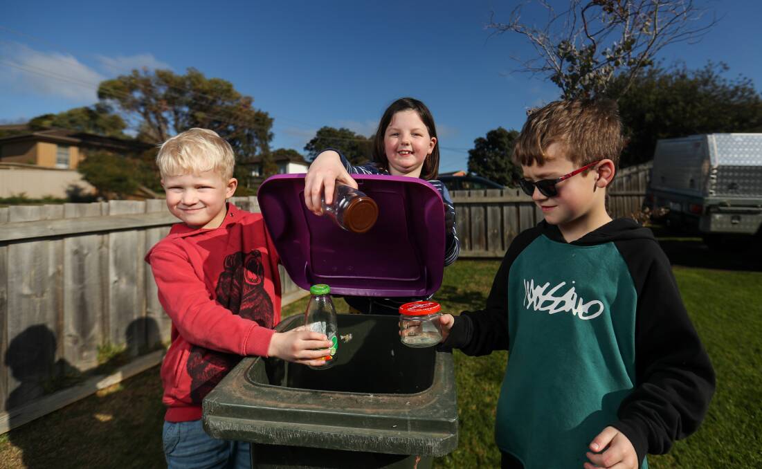 TRIAL A SUCCESS: Alex McRae, 6, Taylah Kelly, 6, and Zac McRae, 8, get ready to recycle glass in the new bin with the purple lid. Picture: Morgan Hancock