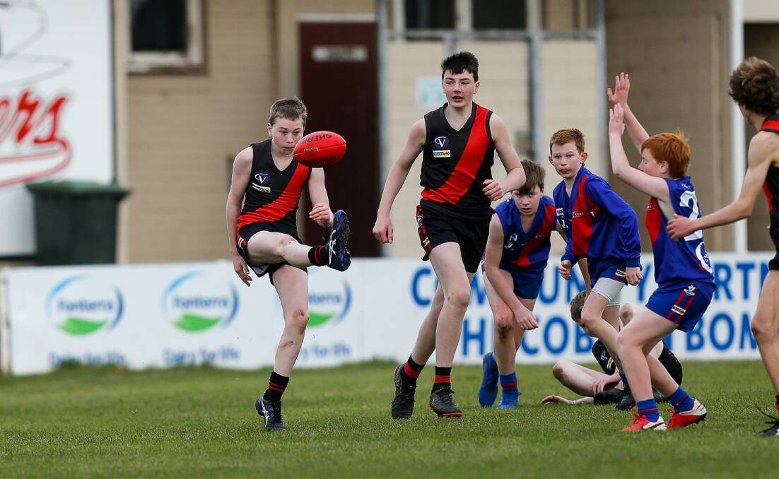 FOOTY FUN: Cobden's Nathan Hallyburton gets a kick away against Terang Mortlake in their under 14 game on Saturday. Picture: Anthony Brady