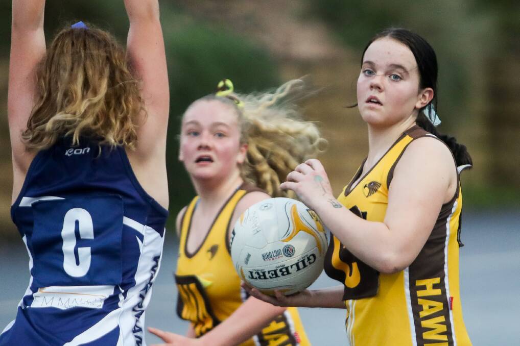 HAVING A BLAST: Hawks' Amali Lilley prepares to pass the ball during a 14 and under netball match against Warrnambool on Wednesday. Hawks play their matches mid-week. Picture: Morgan Hancock