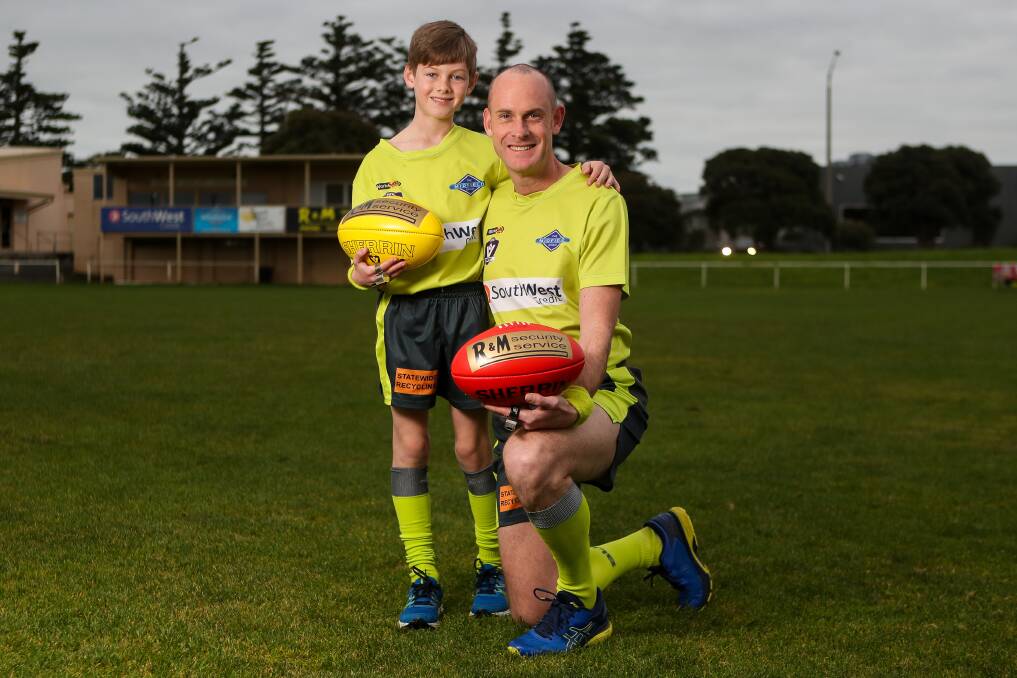 ALL SMILES: Son Michael with his dad Andrew in their football umpiring uniforms. Picture: Morgan Hancock