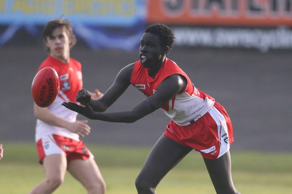 MAKING THE MOST OF IT: South Warrnambool's Mojwok Akoch handballs during the under 18.5 match against Koroit last weekend. Picture: Mark Witte