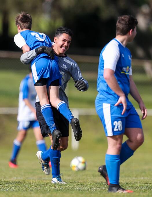 HAVING A BLAST: Oliver Hammond picks up Noel Reid as they celebrate a goal during Warrnambool Rangers' under 17 scratch match on Sunday. Picture: Morgan Hancock