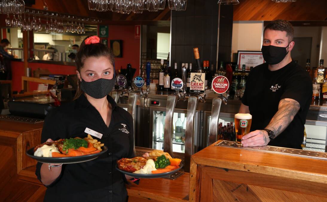 Dine-in: Flying Horse staff Emily Monacella and Dylan Barling serving food and drinks on Wednesday before stage three coronavirus restrictions begin. Picture: Mark Witte