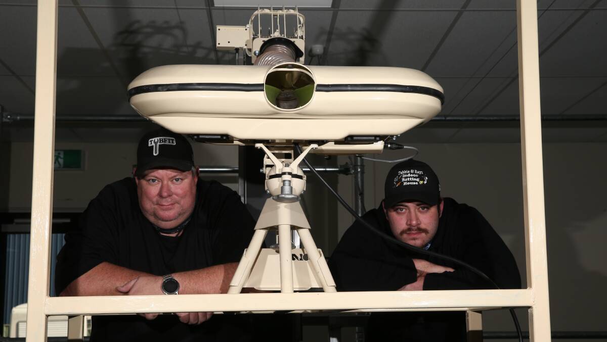 EQUIPED: Steve Taylor and son Anthony with the new bowling machine. Picture: Mark Witte