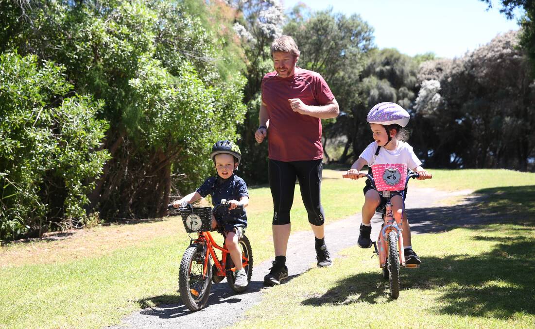 Riding along: Warrnambool Tri Club's Peter Gaffy with daughter Lucy, 5, and son James, 3. They're participating in the Killarney Triathlon this Sunday. Picture: Mark Witte