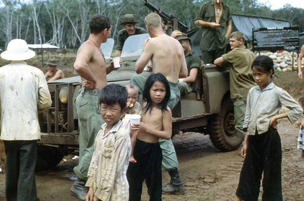 Ken Cumming took this photo of Australian troops helping relocate Vietnamese families to safer areas during the war. 