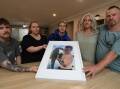 Brayden Chater's family - cousin Callum Young, older sister Stacey, younger brother Harry, mum Stacey and dad Ralph - with a photograph of the keen fisherman taken in Lake Conjola in 2022. Picture by Robert Peet