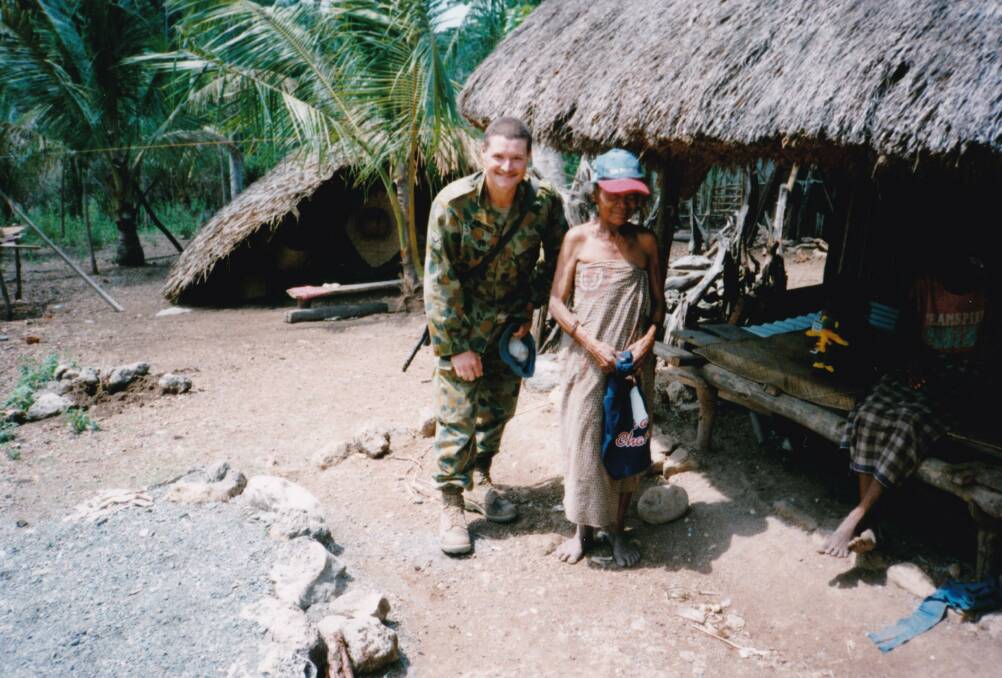 PEACE-KEEPING: Mr Rantall with a Timor Leste local donning a The Standard cap.