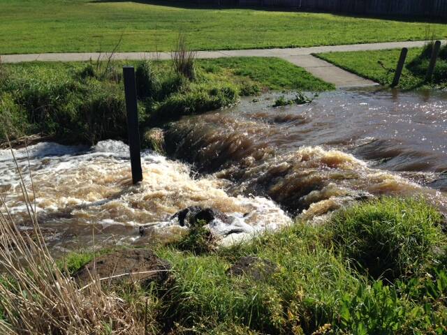 Excessive rain causes a creek to run and block a walkway near Renoir and Cherlin drives in Warrnambool.