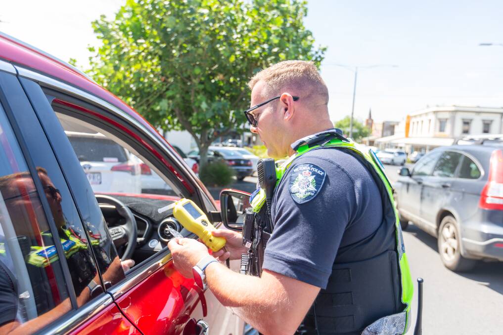 A Warrnambool police officer conducts a breath test in the CBD on Tuesday. More members will be seen on the region's roads from today for Operation Amity.
