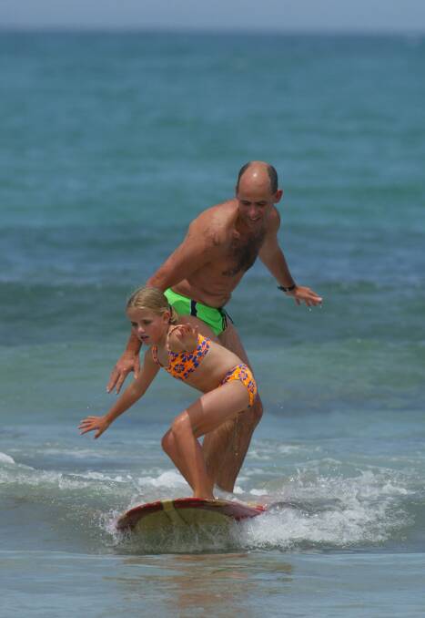 SURFS UP: Tony Robinson rides a wave with daughter Erica at a Warrnambool beach during the summer holidays in the late 1990s.
