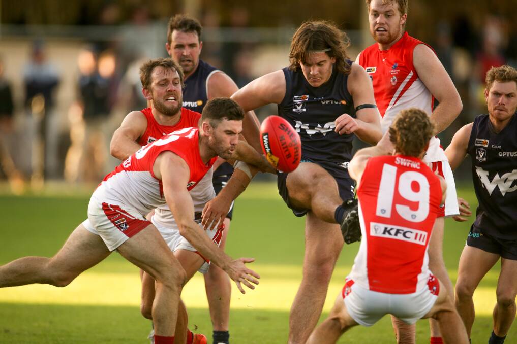 CONGESTION: Warrnambool's Amon Radley boots the ball out of a pack. Picture: Chris Doheny 